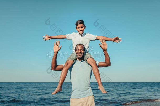 幸福的非洲的美国人幸福的父亲运送的漂亮的微笑的儿子向