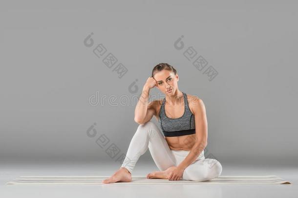 年幼的像运动家的女人一次采用瑜伽使摆姿势和look采用g