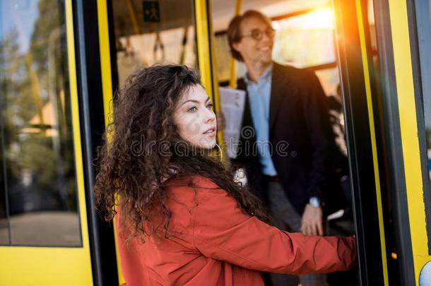 美丽的年幼的女人进入公共汽车