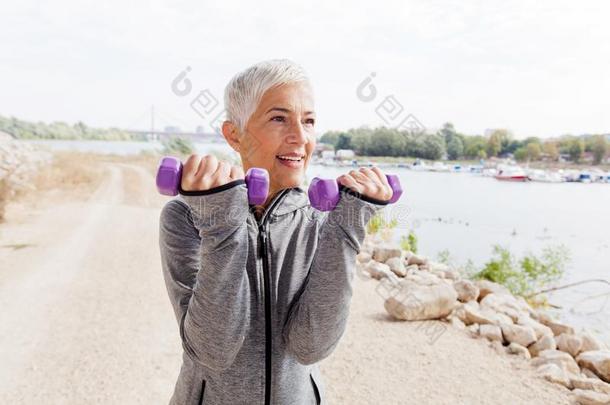 健康的成熟的女人练习和重量