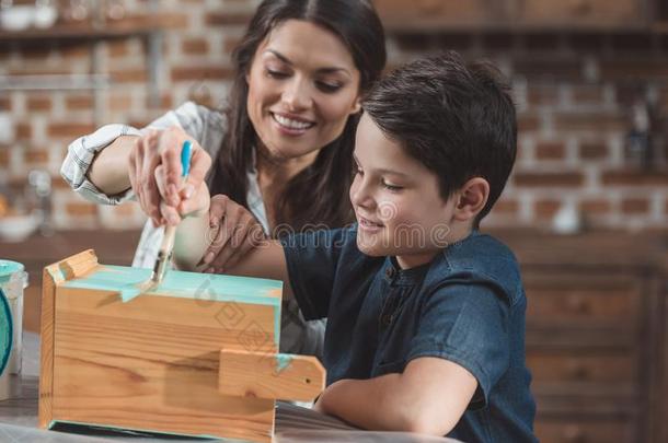 年幼的母亲的一份小的儿子向颜料一