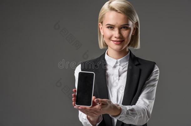 肖像关于微笑的女人展映智能手机和空白的屏幕