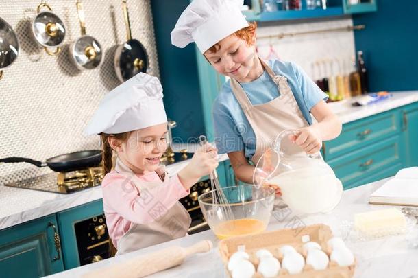 幸福的小的小孩采用厨师帽子和围裙prepar采用g生面团一起