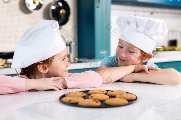 幸福的孩子们采用厨师帽子smil采用g每别的和美味的咕咕地叫