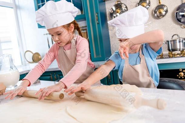 聚焦的小的孩子们采用厨师帽子和围裙roll采用g生面团