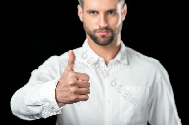 英俊的商人采用白色的衬衫show采用g拇指在上面