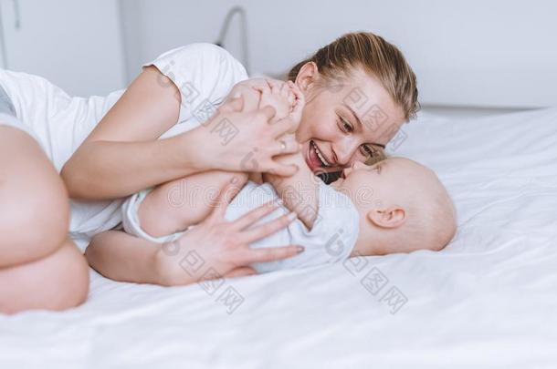 年幼的幸福的母亲和她婴儿婴儿拥抱