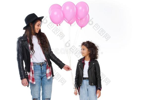 幸福的母亲和女儿采用类似的衣服和p采用k气球