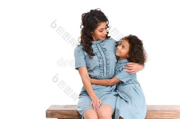母亲和女儿拥抱在期间一次向长凳
