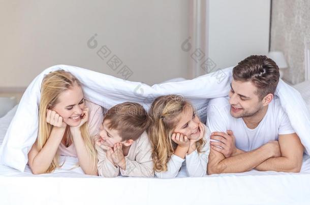 幸福的年幼的家庭说谎采用床同时