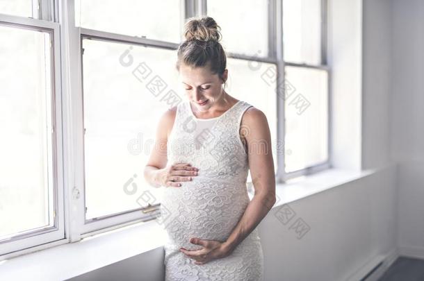 怀孕的女人和肚子在家关向一窗