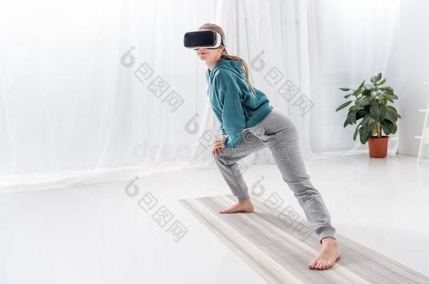 女孩伸木头支架和VirtualReality虚拟现实戴在头上的耳机或听筒向瑜伽席子