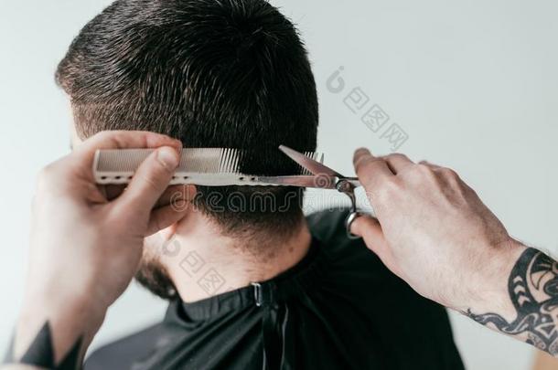 裁切不正的影像关于理发师锋利的顾客头发和剪刀和