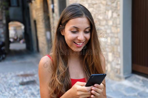 微笑的女人使用可移动的电话计算机应用程序向比赛磁带录像运动在线的.