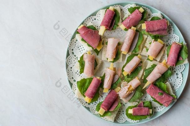 夹<strong>鱼</strong>子或小<strong>鱼</strong>的烤面包火腿有<strong>包装</strong>的和奶酪和绿叶蔬菜采用圆形的盘子.