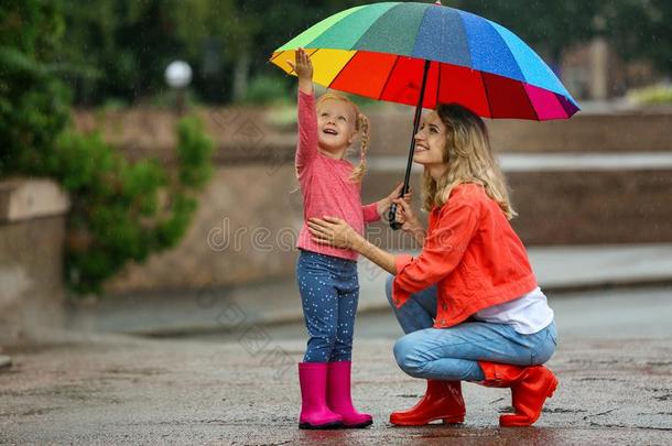 幸福的母亲和女儿和明亮的雨伞