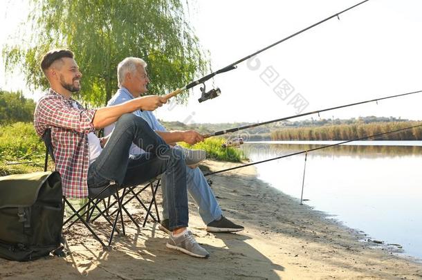 父亲和成熟的儿子捕鱼同时从<strong>河边</strong>