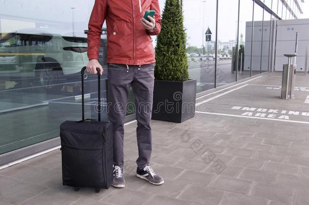 一男人和手提箱和可移动的电话在近处关于机场.