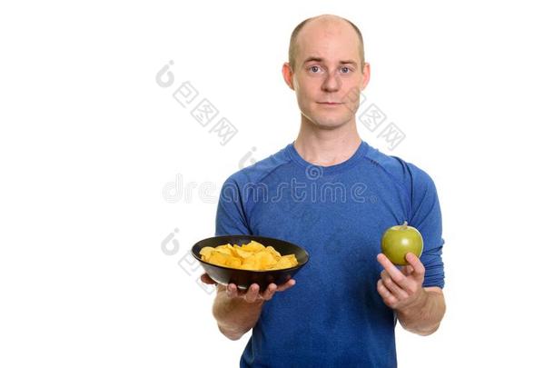 秃头的高加索人男人佃户租种的土地碗关于马铃薯炸马铃薯条和绿色的苹果