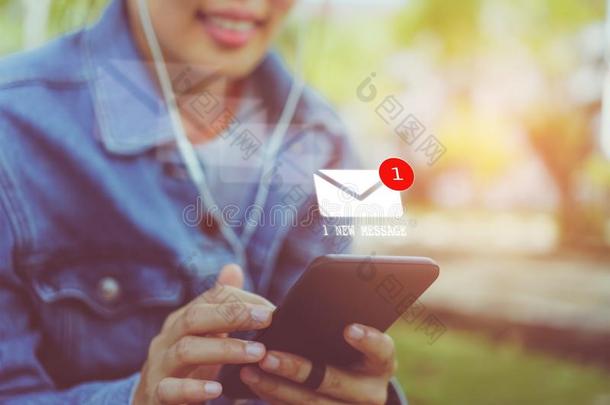 女人手使用智能手机向送和收到电子邮件.
