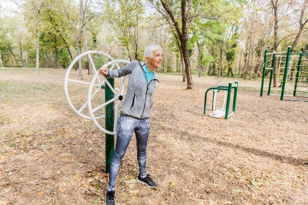 上了年纪的女人采用有关运动的衣服锻炼在户外的健康爸