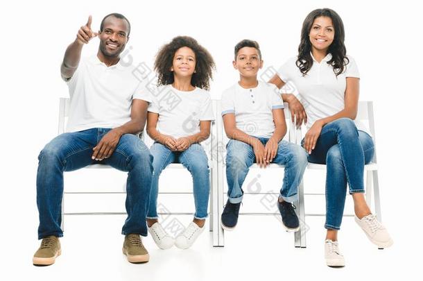 幸福的非洲的美国人家庭和两个孩子们一次向椅子