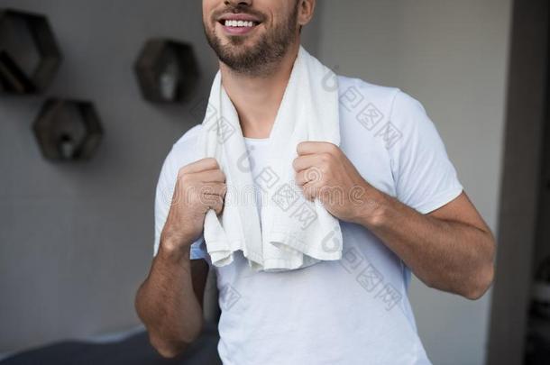 年幼的微笑的男人使摆姿势采用家衣服和毛巾