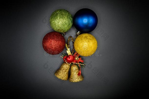 金色的钟和富有色彩的圣诞节小玩意向黑的背景.