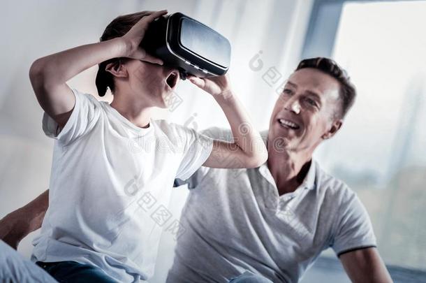 吃惊的小的男孩仔细检查指已提到的人VirtualReality虚拟现实眼镜<strong>开幕</strong>他的口.
