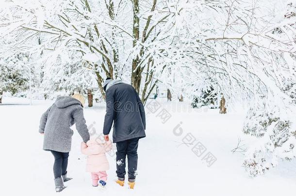 幸福的年幼的家庭步态和婴儿向冬大街,妈妈,爸爸,英语字母表的第3个字母