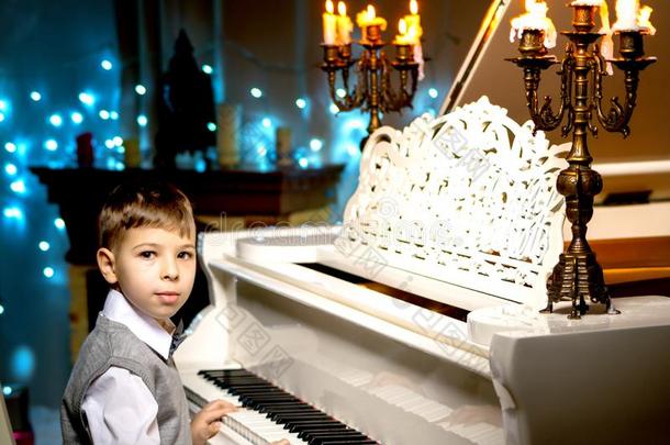 一小的男孩是（be的三单形式演奏指已提到的人钢琴.