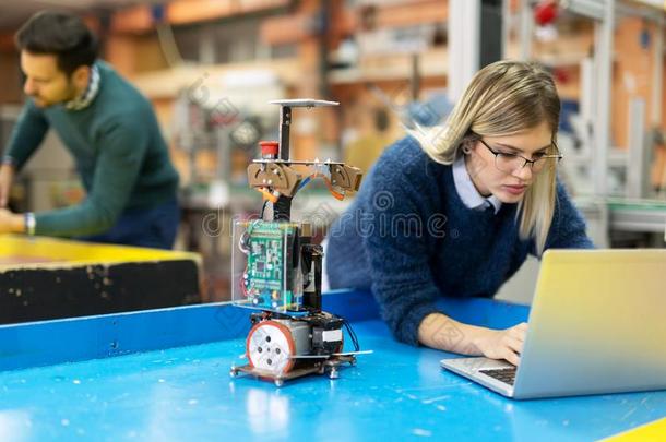 年幼的女人工程师工作的向机器人技术放映