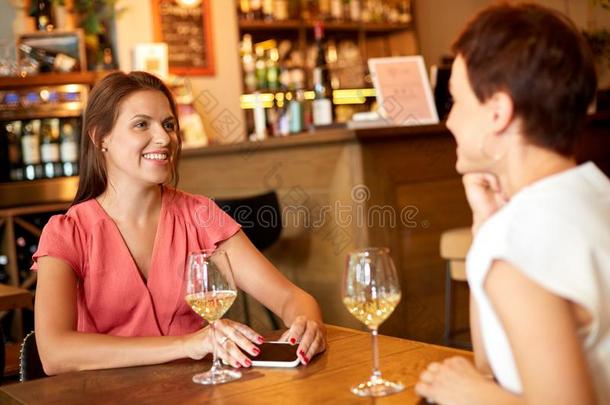 幸福的女人喝饮料葡萄酒在条或饭店