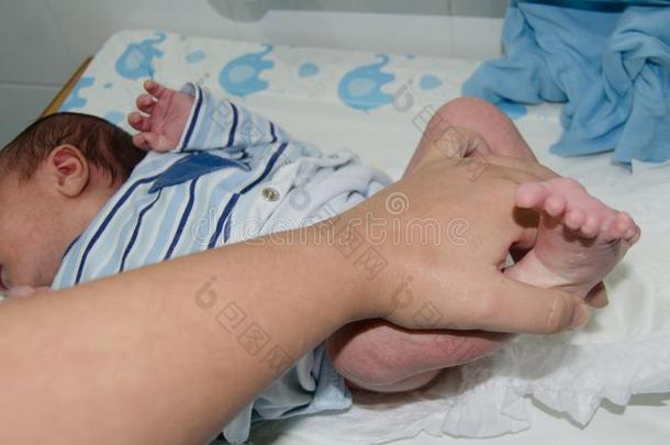 母亲手替<strong>换新</strong>生的婴儿尿布向婴儿改变者