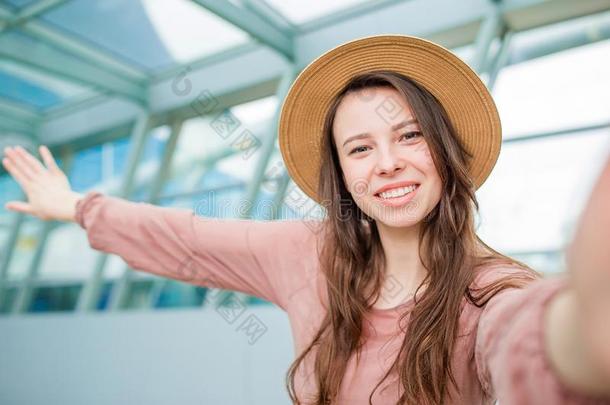 年幼的女人迷人的自拍照一机场休息厅等候为木板
