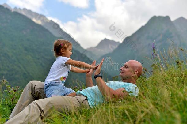 小的女孩演奏和她爸爸向指已提到的人绿色的草.