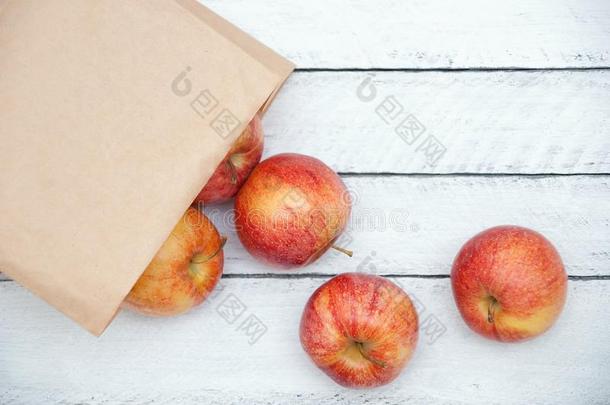 苹果是分散的从指已提到的人牛皮纸包装向一白色的木制的b一