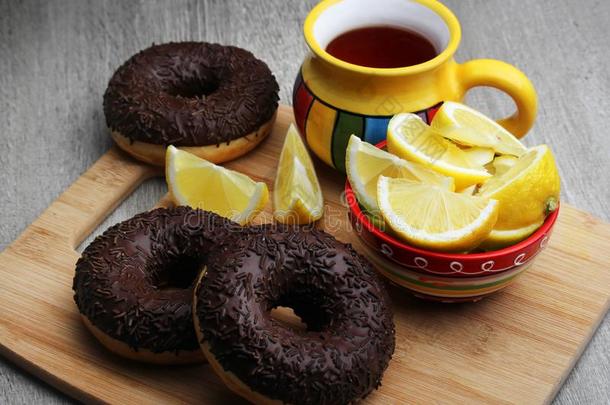 巧克力油炸圈饼和茶水和柠檬为早餐