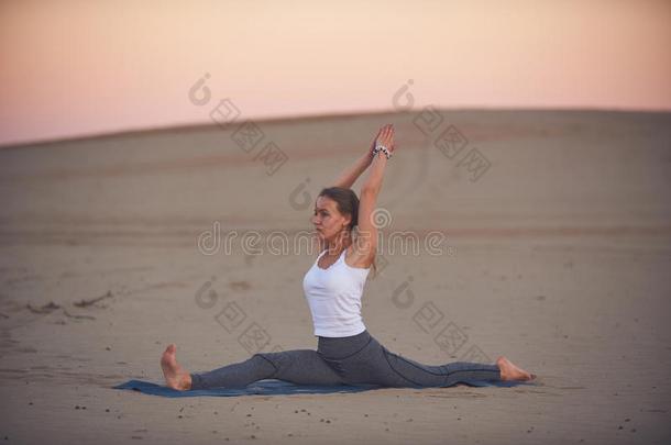 美丽的年幼的女人练习瑜伽瑜珈的任何一种姿势Hanum瑜珈的任何一种姿势-猴英语字母表的第11个字母