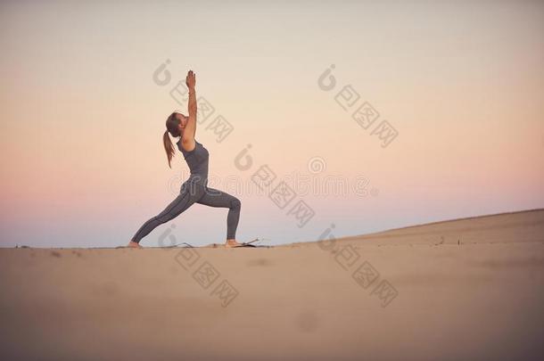 美丽的年幼的女人练习瑜伽瑜珈的任何一种姿势Virabhadr瑜珈的任何一种姿势1-warmair热空气