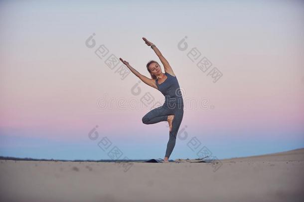 美丽的年幼的女人练习瑜伽瑜珈的任何一种姿势帕塞克Vriksh瑜珈的任何一种姿势-