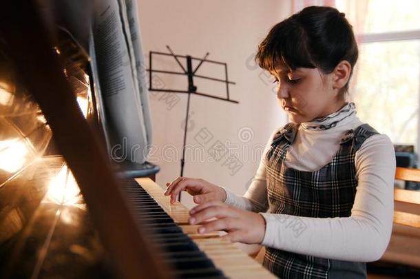 一小的女孩演奏钢琴向音乐less向.美丽的阳光