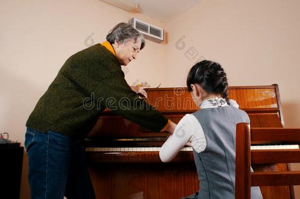 一小的女孩演奏<strong>钢琴</strong>向音乐less向.一<strong>教师</strong>的一份英语字母表的第8个字母