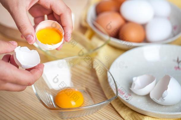 女人手破坏一鸡蛋向分开鸡蛋白色的一d蛋黄,鸡蛋