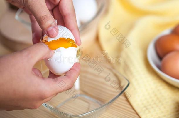 女人手破坏一鸡蛋向分开鸡蛋白色的一d蛋黄,鸡蛋