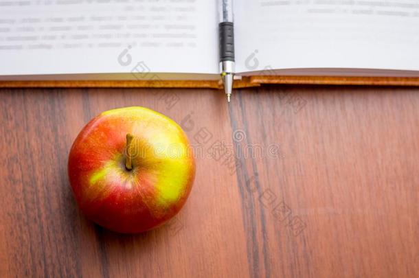 成熟的多汁的红色的苹果在近处指已提到的人书和笔.<strong>有用</strong>的食物在的时候一