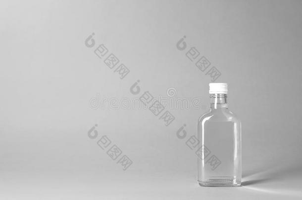 瓶子关于酒精的喝向灰色的背景.