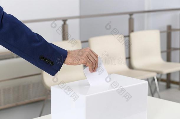 男人放置他的投票进入中投票盒在投票st在ion