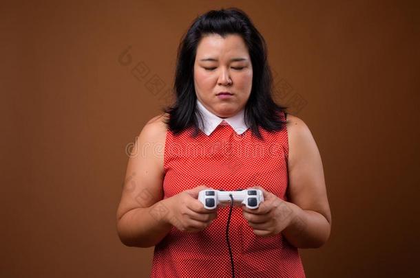 美丽的超重的亚洲人女人演奏磁带录像运动使用游戏