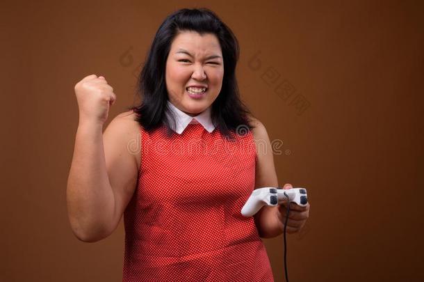 幸福的超重的亚洲人女人演奏磁带录像运动使用游戏contents内容